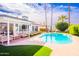 Inviting backyard pool with lounge chairs and manicured grass, set against a backdrop of palm trees at 10640 E Mercer Ln, Scottsdale, AZ 85259