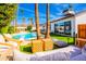 Backyard oasis with a sparkling pool, lush landscaping, a covered patio, and comfortable outdoor seating at 10640 E Mercer Ln, Scottsdale, AZ 85259