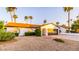 Charming single-story home featuring a desert landscape, palm trees, and a two-car garage at 10640 E Mercer Ln, Scottsdale, AZ 85259