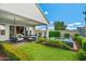 Inviting backyard featuring a covered patio, outdoor kitchen, and a lovely spa surrounded by lush greenery at 11878 N Hershey St, Surprise, AZ 85388
