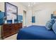 Contemporary bedroom with a sleek dresser, blue accent wall, and minimalist decor at 11878 N Hershey St, Surprise, AZ 85388
