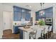 Well-equipped kitchen featuring blue cabinets, a spacious center island with seating, and a view of the pantry at 11878 N Hershey St, Surprise, AZ 85388