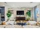 Cozy living room featuring a stone accent wall, a media center, and comfortable seating, accented with lush plants at 11878 N Hershey St, Surprise, AZ 85388