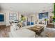 Spacious living room with an inviting white sectional, adjacent to a modern kitchen with blue cabinets and bar seating at 11878 N Hershey St, Surprise, AZ 85388