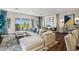 Bright living room featuring a comfortable white sectional sofa, stylish decor, and backyard access through sliding glass doors at 11878 N Hershey St, Surprise, AZ 85388