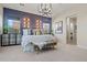 Spacious primary bedroom showcasing a stylish accent wall, modern lighting, and a cozy bench at 11878 N Hershey St, Surprise, AZ 85388