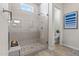Tiled shower features a frameless glass enclosure, a large shower head, and seating niche at 11878 N Hershey St, Surprise, AZ 85388