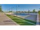 View of community tennis court with pristine surface, professional lighting, and manicured landscaping at 11878 N Hershey St, Surprise, AZ 85388