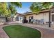 Spacious backyard with brick patio, artificial grass, shade trees, and outdoor seating, perfect for entertaining guests at 12001 N 53Rd Ave, Glendale, AZ 85304