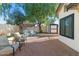 Cozy backyard features a brick patio, comfortable seating, and a charming swing under a shady tree at 12001 N 53Rd Ave, Glendale, AZ 85304