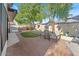 Relaxing backyard with brick patio, artificial grass, mature trees, and comfortable seating, ideal for outdoor enjoyment at 12001 N 53Rd Ave, Glendale, AZ 85304