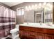 Well-lit bathroom with a double vanity and a shower featuring a stylish curtain, offering a functional design at 1401 E Brentrup Dr, Tempe, AZ 85283