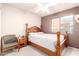 Calm bedroom with a wooden bed frame, a cozy chair, and a view through the window, offering a peaceful retreat at 1401 E Brentrup Dr, Tempe, AZ 85283