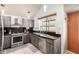Modern kitchen featuring stainless steel appliances, granite countertops, and tile flooring at 1401 E Brentrup Dr, Tempe, AZ 85283