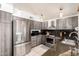 Modern kitchen featuring stainless steel appliances, sleek gray cabinets, and granite countertops at 1401 E Brentrup Dr, Tempe, AZ 85283
