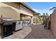 A well-maintained backyard with a covered patio, desert landscaping, and modern grill setup for outdoor relaxation at 144 W Bahamas Dr, Casa Grande, AZ 85122