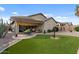 Charming backyard with artificial turf, desert-themed landscaping, and a covered patio for outdoor enjoyment at 144 W Bahamas Dr, Casa Grande, AZ 85122