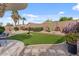 A beautifully landscaped backyard featuring artificial turf, desert plants, and a gravel border for a tranquil outdoor space at 144 W Bahamas Dr, Casa Grande, AZ 85122