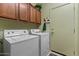 Dedicated laundry room area with washer, dryer, and storage cabinets at 144 W Bahamas Dr, Casa Grande, AZ 85122
