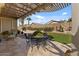 Comfortable covered patio boasts a well-kept artificial lawn, pergola, and desert landscaping for a cozy outdoor experience at 144 W Bahamas Dr, Casa Grande, AZ 85122