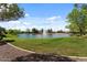Scenic community pond with a tranquil fountain, lush green surroundings, and a walking path, creating a peaceful atmosphere at 144 W Bahamas Dr, Casa Grande, AZ 85122