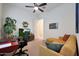 Relaxing bedroom featuring a sofa, ceiling fan, desk, and television at 14939 S 185Th Ave, Goodyear, AZ 85338