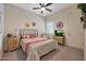 Bright bedroom features a ceiling fan, patterned bedding, side tables, and natural light at 14939 S 185Th Ave, Goodyear, AZ 85338