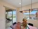 Sunlit dining area with modern chandelier, featuring an open sliding door with views of the private pool and mountain landscapes at 14939 S 185Th Ave, Goodyear, AZ 85338