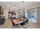 Open concept dining area features a wooden table, modern lighting, and access to the outdoor patio, seamlessly blending indoor and outdoor living at 14939 S 185Th Ave, Goodyear, AZ 85338