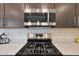 Close up view of stainless gas range and microwave featuring a quartz countertop and stylish cabinetry, a modern kitchen's centerpiece at 14939 S 185Th Ave, Goodyear, AZ 85338