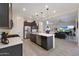 Modern kitchen flows into the living area, showcasing an open-concept design with stainless appliances and ample counter space at 14939 S 185Th Ave, Goodyear, AZ 85338