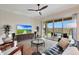 Cozy living room features modern furniture, a ceiling fan, and large windows offering scenic views of the outdoor pool area at 14939 S 185Th Ave, Goodyear, AZ 85338