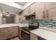 Beautiful kitchen with stainless appliances, gas range, breakfast bar, decorative backsplash, and wood cabinets at 1545 E Sahuaro Dr # 12, Phoenix, AZ 85020