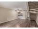 Open concept living room features wood-look flooring, breakfast bar, stairway, and ceiling fan at 1545 E Sahuaro Dr # 12, Phoenix, AZ 85020