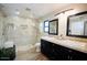 Modern bathroom with glass shower, dual sink vanity with dark cabinets, and attractive fixtures at 16010 N 64Th Dr, Glendale, AZ 85306
