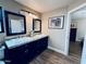 Bathroom featuring a dual sink vanity with granite top and dark cabinets and modern fixtures at 16010 N 64Th Dr, Glendale, AZ 85306