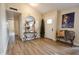 Inviting foyer features wood-look flooring, a round mirror, console table, and interior door at 16010 N 64Th Dr, Glendale, AZ 85306