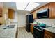 Bright kitchen showcasing stainless steel appliances, granite countertops, and wood cabinets with great natural light at 16010 N 64Th Dr, Glendale, AZ 85306