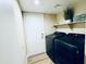 Convenient laundry room featuring a modern washer and dryer, storage shelf, and stylish flooring at 16010 N 64Th Dr, Glendale, AZ 85306