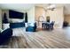 Open-concept living room with wood-look flooring, skylight, and stylish furnishings at 16010 N 64Th Dr, Glendale, AZ 85306