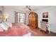 Bright bedroom featuring hardwood floors, desk, and a large wooden wardrobe at 16857 E Deuce Ct, Fountain Hills, AZ 85268