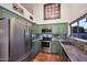 Bright kitchen with stainless steel appliances, green cabinetry, and terra cotta tile flooring at 16857 E Deuce Ct, Fountain Hills, AZ 85268