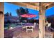 Covered patio featuring outdoor dining area overlooking the lush landscaped backyard and pool at 16857 E Deuce Ct, Fountain Hills, AZ 85268