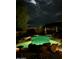 Inviting pool at night with underwater lights and decorative rocks create a relaxing backyard oasis at 16857 E Deuce Ct, Fountain Hills, AZ 85268
