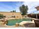 Backyard oasis with a beautiful pool, rock waterfall, desert landscaping, and lounge area at 16857 E Deuce Ct, Fountain Hills, AZ 85268