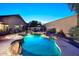 A refreshing backyard pool with a rock waterfall, lush landscaping, and inviting lounge areas at 16857 E Deuce Ct, Fountain Hills, AZ 85268