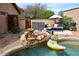 Relaxing backyard space with a waterfall feature, pool, and comfortable seating area at 16857 E Deuce Ct, Fountain Hills, AZ 85268