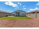 Well-maintained backyard with artificial grass, a barbecue grill, and a view of the home's exterior at 17454 W Red Fox Rd, Surprise, AZ 85387