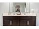 Bathroom vanity with dual sinks, white countertops, and dark wood cabinets with modern hardware at 17454 W Red Fox Rd, Surprise, AZ 85387