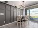 Dining room featuring a wooden table and chairs, custom wall trim, and a sliding glass door at 17454 W Red Fox Rd, Surprise, AZ 85387